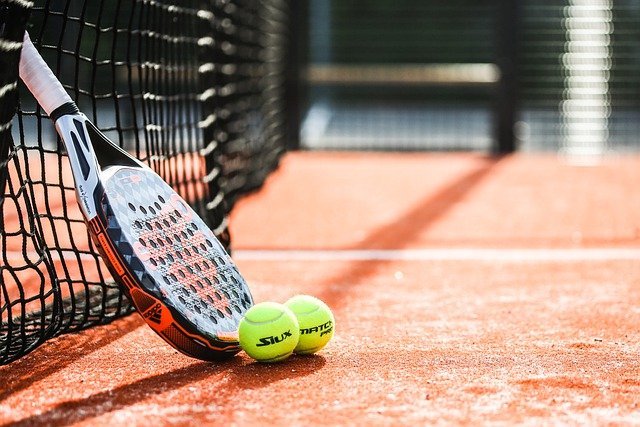 campo da padel rosso con racchetta e palline